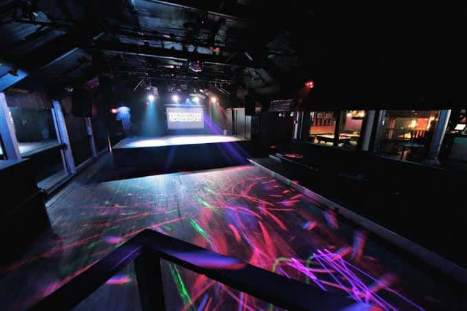 Vista del interior del club Elysium con escenario y luces de discoteca