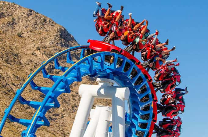 Montaña rusa con pasajeros en posición invertida sobre la pista