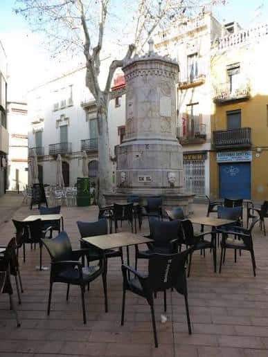 Plaza con mesas y sillas alrededor de la fuente, ideal para eventos al aire libre