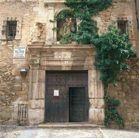 Entrada principal de la Posada de San José con puerta de madera y decoración de hiedra