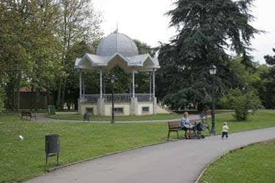 Kiosco con cúpula en el Parque de Ferrera, con personas descansando en bancos