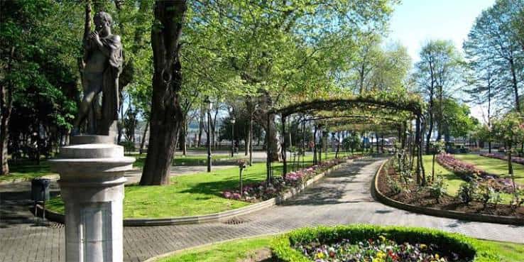 Estatua y pérgola con flores en el Parque de Ferrera, Avilés