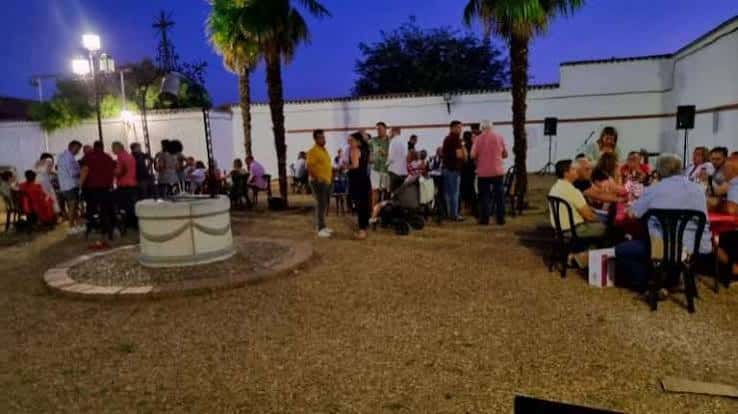 Evento al aire libre en el patio del centro cultural con invitados y palmeras