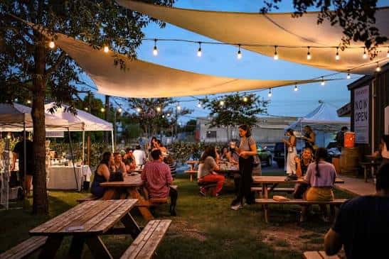 Evento nocturno en el patio con luces y gente reunida