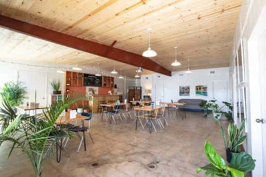 Espacio interior amplio con techo de madera y mesas para eventos
