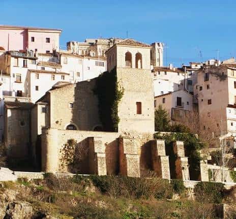 Fachada lateral de la Iglesia de San Miguel con muros de piedra y campanario