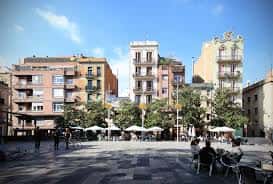Plaza abierta con terrazas de cafés y edificios históricos al fondo bajo cielo despejado