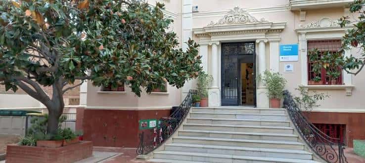 Vista frontal de la entrada principal de la Escola Heura con escalinata y fachada clásica