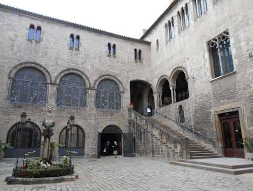 Patio interior del Palau Episcopal con escalinata y ventanales góticos