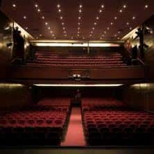 Vista panorámica del interior del auditorio con butacas rojas y techo estrellado