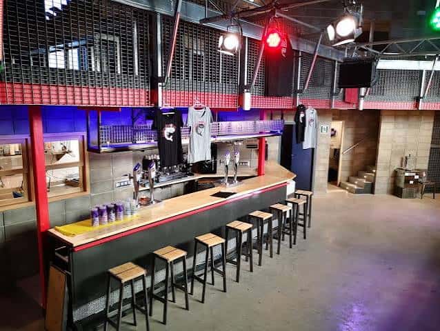 Interior del bar con barra de madera y taburetes