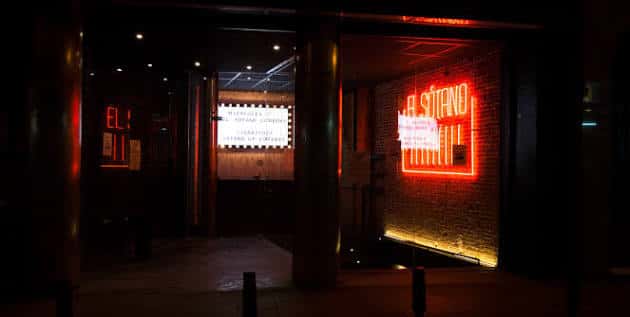 Entrada nocturna del local El Sótano con su icónico letrero de neón