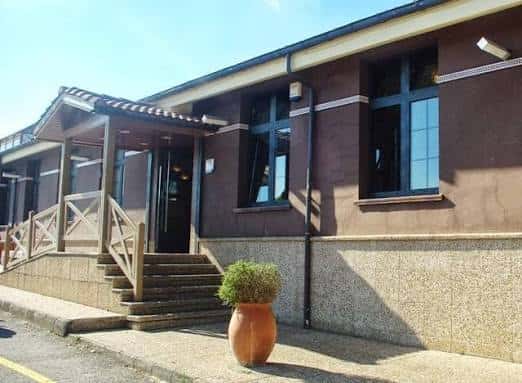 Fachada del edificio principal de La Carbayera de Granda con escalera de acceso