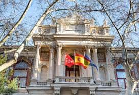 Fachada principal de la Escuela de Minas con banderas y arquitectura neoclásica