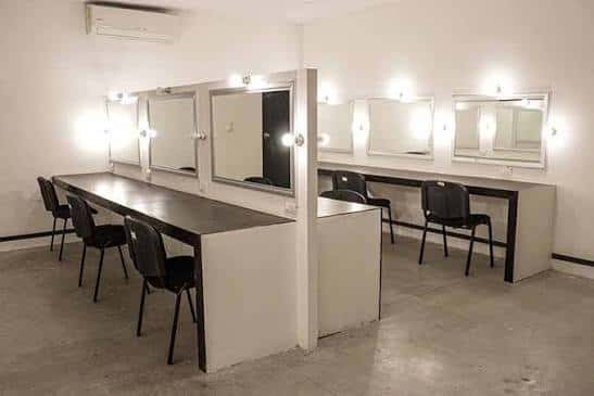 Vestidores del teatro con espejos y mesas de maquillaje