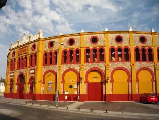 Vista exterior de la Plaza de Toros de Sanlúcar de Barrameda con su fachada amarilla y roja
