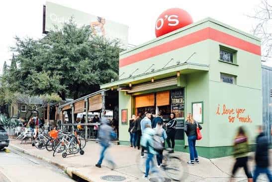 Vista exterior del local de Jo's Coffee con su icónica señal redonda y fachada verde
