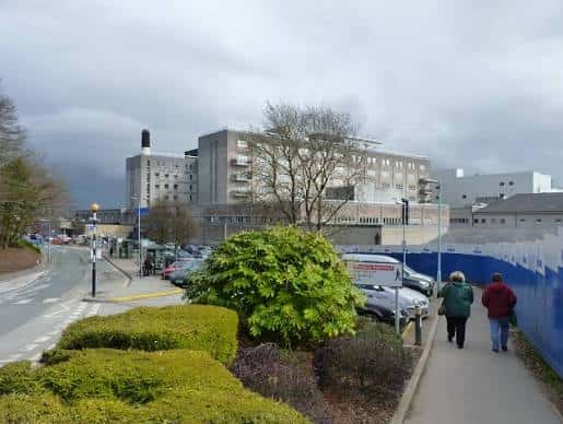Exterior del Derriford Hospital con camino peatonal y vegetación en primer plano