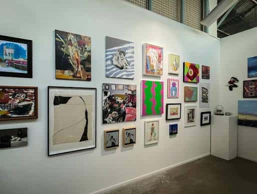Interior de la galería con obras de arte expuestas en las paredes