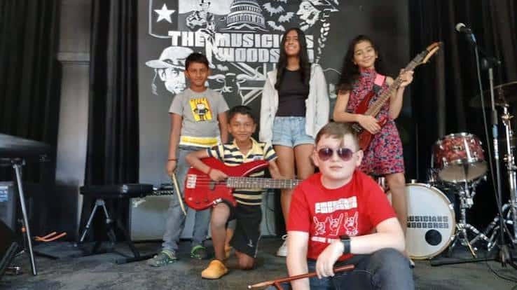 Grupo de estudiantes de música posando en el escenario