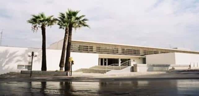 Fachada principal de la Escola Saavedra con palmeras y escalinata