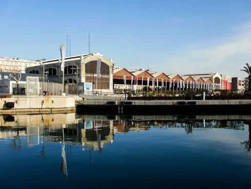Vista panorámica del complejo de Tinglados desde el puerto con reflejos en el agua