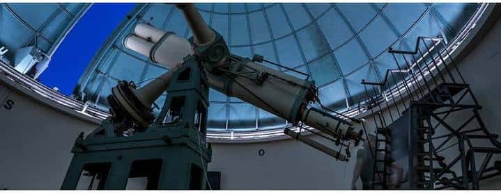 Interior del observatorio con telescopio histórico bajo cúpula abierta
