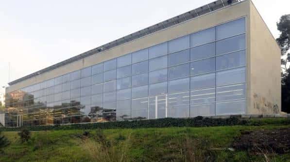 Fachada moderna de la biblioteca con grandes ventanales y entorno natural