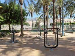 Zona de parque con palmeras y equipamiento de ejercicio al aire libre