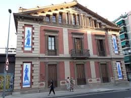Fachada del Casal de Barri Torre de la Sagrera con carteles de eventos y personas caminando