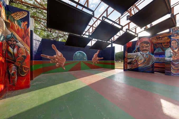 Interior del escenario con techo abierto y pinturas murales vibrantes