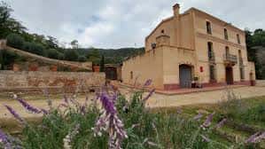 Fachada del edificio del Centre de Natura rodeado de vegetación y flores