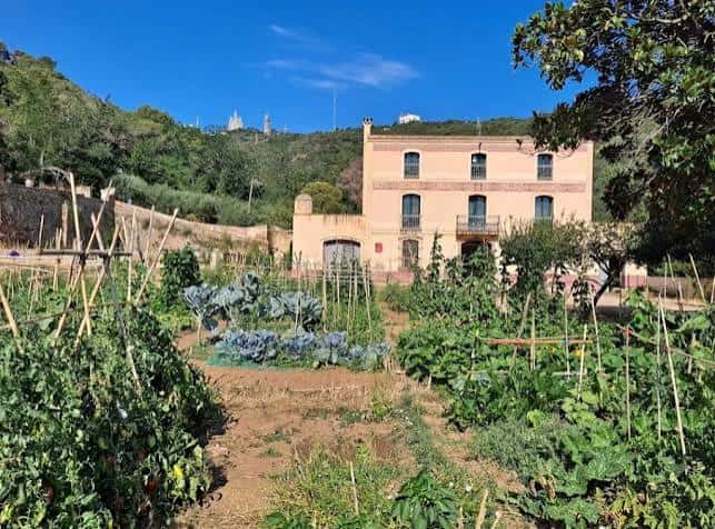 Centro de Naturaleza Can Soler con jardín comunitario y vista de la ciudad al fondo