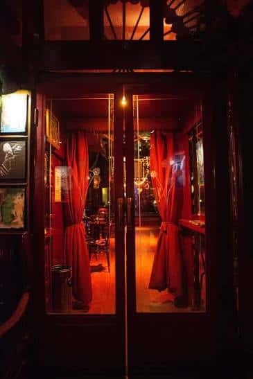 Entrada principal con puertas de cristal y cortinas rojas