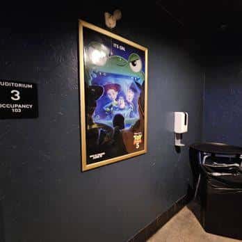 Pasillo del auditorio con cartel de película y señalización de aforo