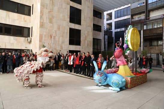 Evento cultural en el patio del centro con danza del león y decoración festiva