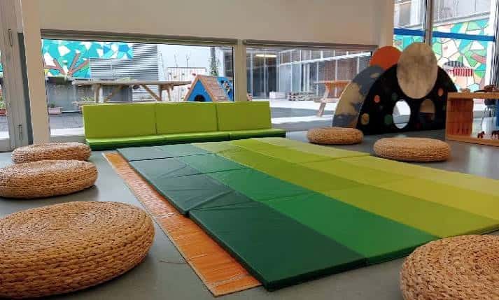 Zona de descanso con cojines y colchonetas en tonos verdes