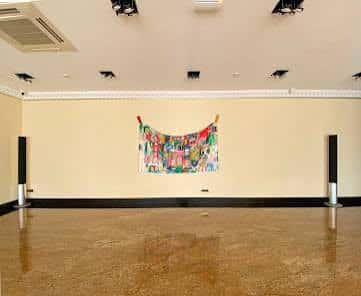 Sala de exposiciones vacía con obra de arte en la pared