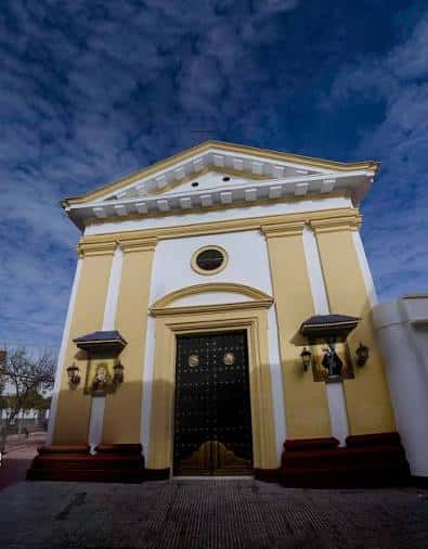 Vista frontal de la fachada de la iglesia con cielo azul