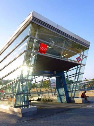 Vista exterior moderna de la estación de metro San Nicasio con estructura de cristal y acero