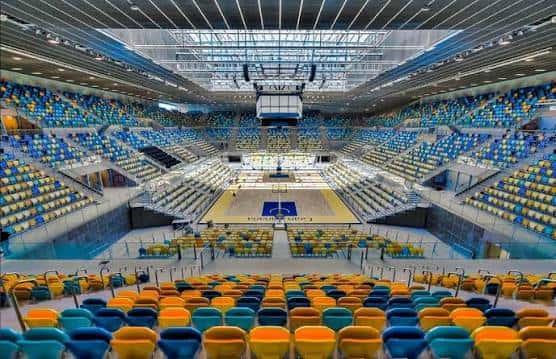 Vista panorámica del interior del Gran Canaria Arena con gradas de colores y pista de baloncesto