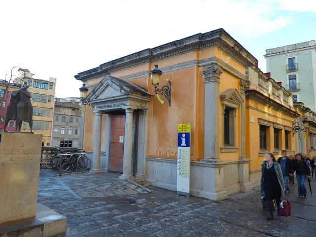 Vista exterior de la Sala Fidel Aguilar en Girona, mostrando su fachada amarilla y entrada principal
