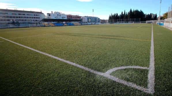 Campo de fútbol artificial del Canyars con líneas blancas marcadas y gradas al fondo en un día soleado