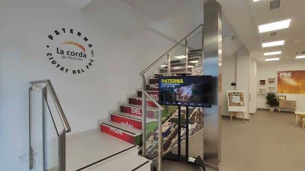 Interior de la oficina de turismo mostrando la escalera y el logo de la ciudad