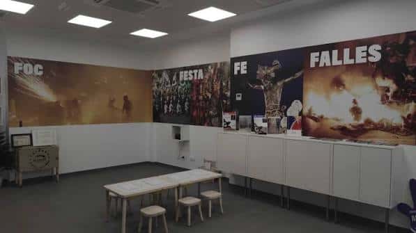 Sala de exposiciones interior con murales sobre las Fallas y la cultura local