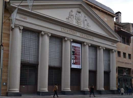 Vista frontal del Teatro Olimpia con cartel de evento y peatones