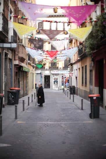 Vista de la calle con decoración festiva y transeúnte caminando