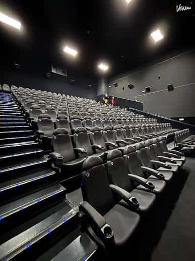 Interior de sala de cine con butacas modernas y escalones iluminados