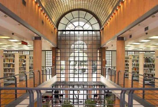 Vista del atrio principal con cúpula de cristal y estanterías de libros