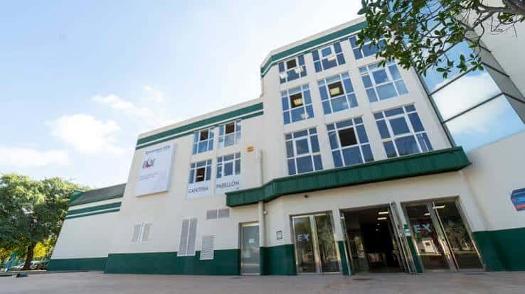 Vista exterior del Pabellón Esperanza Lag con fachada blanca y detalles en verde